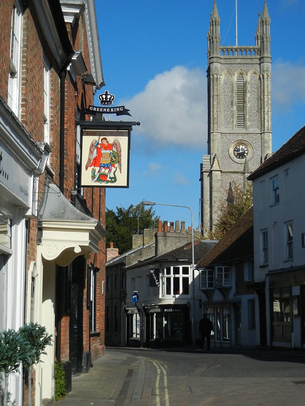A local Green King pub in Andover with a church overlooking and clear skies.