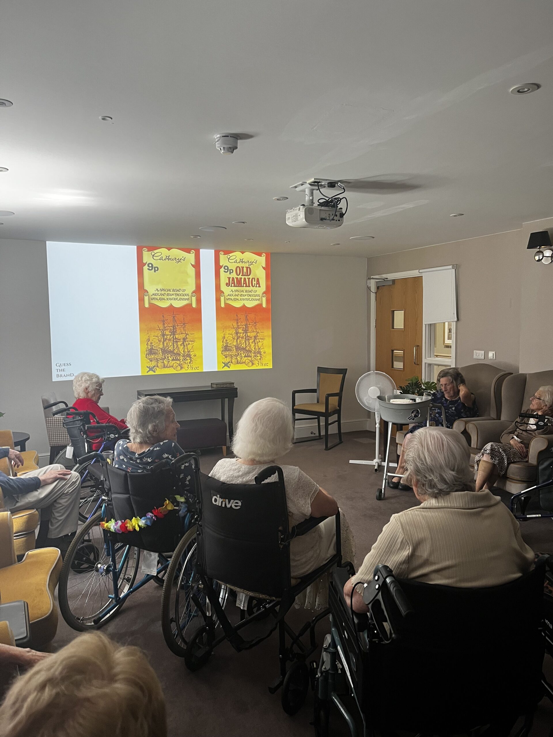 Our residents sat together watching a television programme on a projector at Harrier Grange Care Home