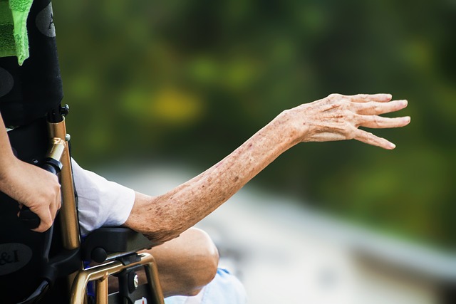 A hand reaches out from a wheelchair 