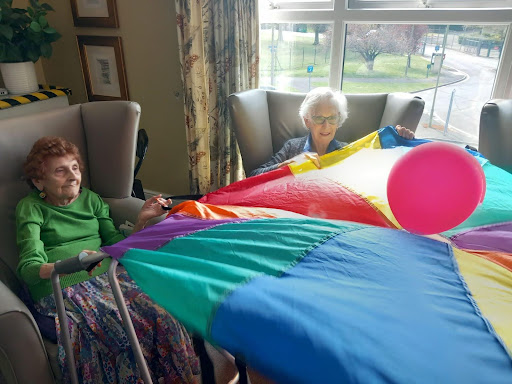 residents playing with a balloon on a parachute