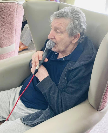 stefano one of our residents sat in an armchair singing into a microphone