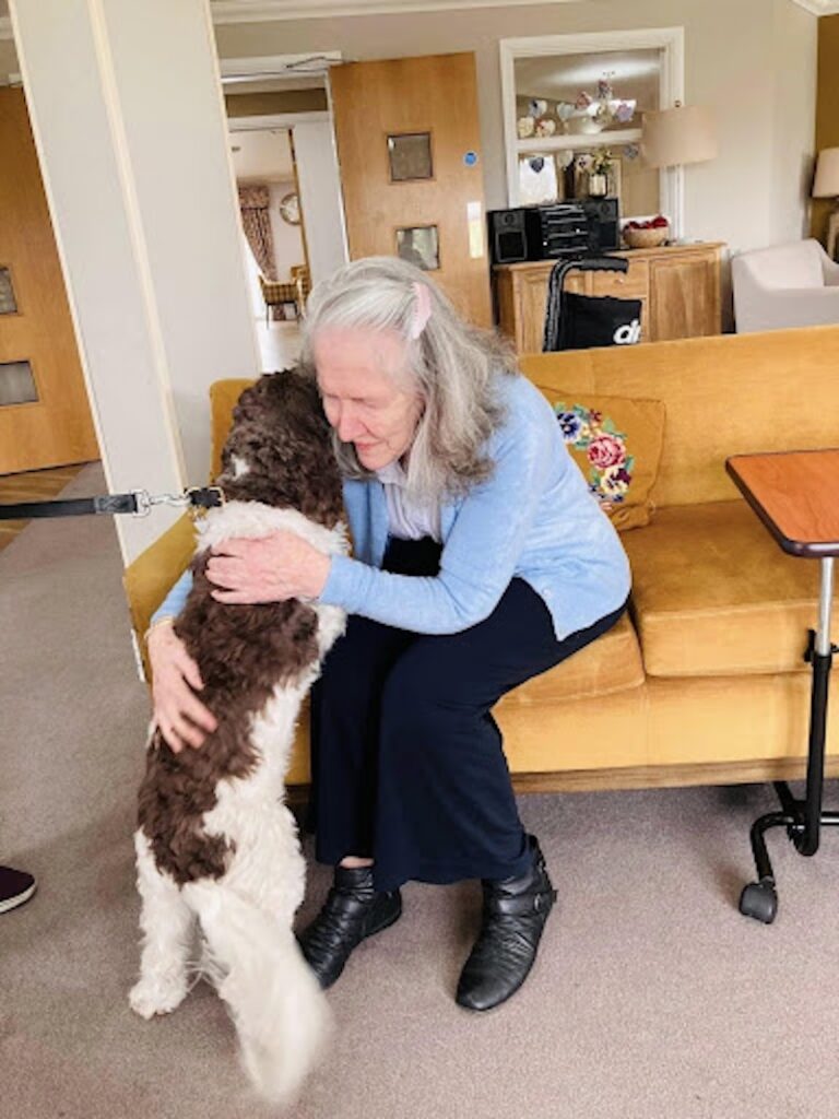 mary, one of our residents hugging a dog