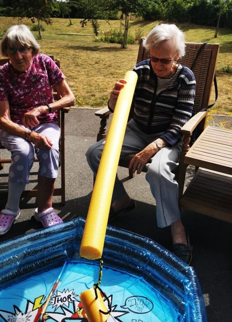 residents playing pool noodle fishing