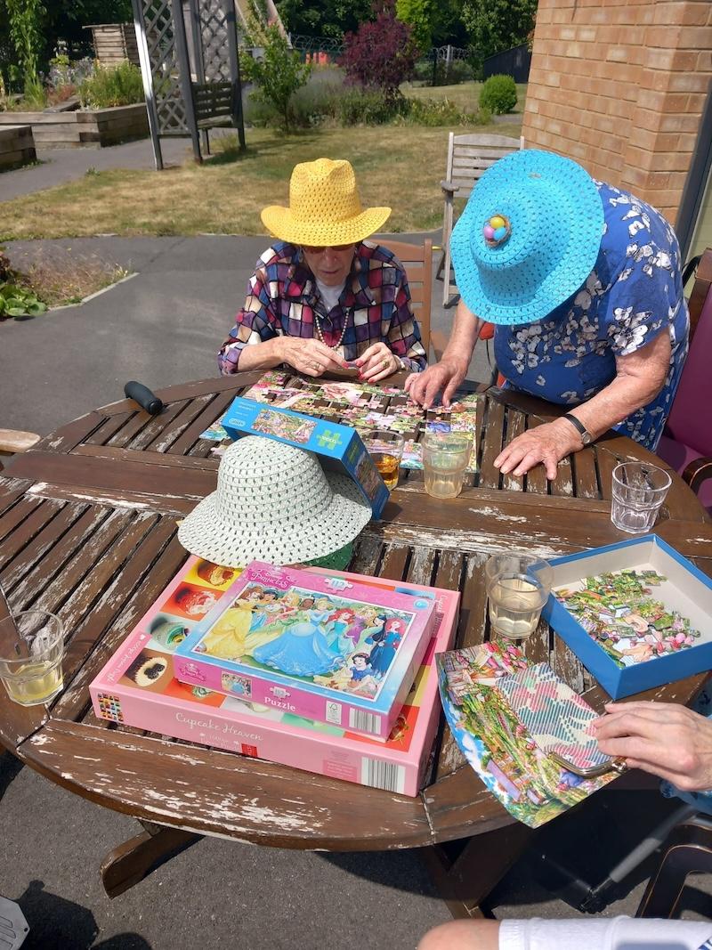 group of residents sat together doing a puzzle
