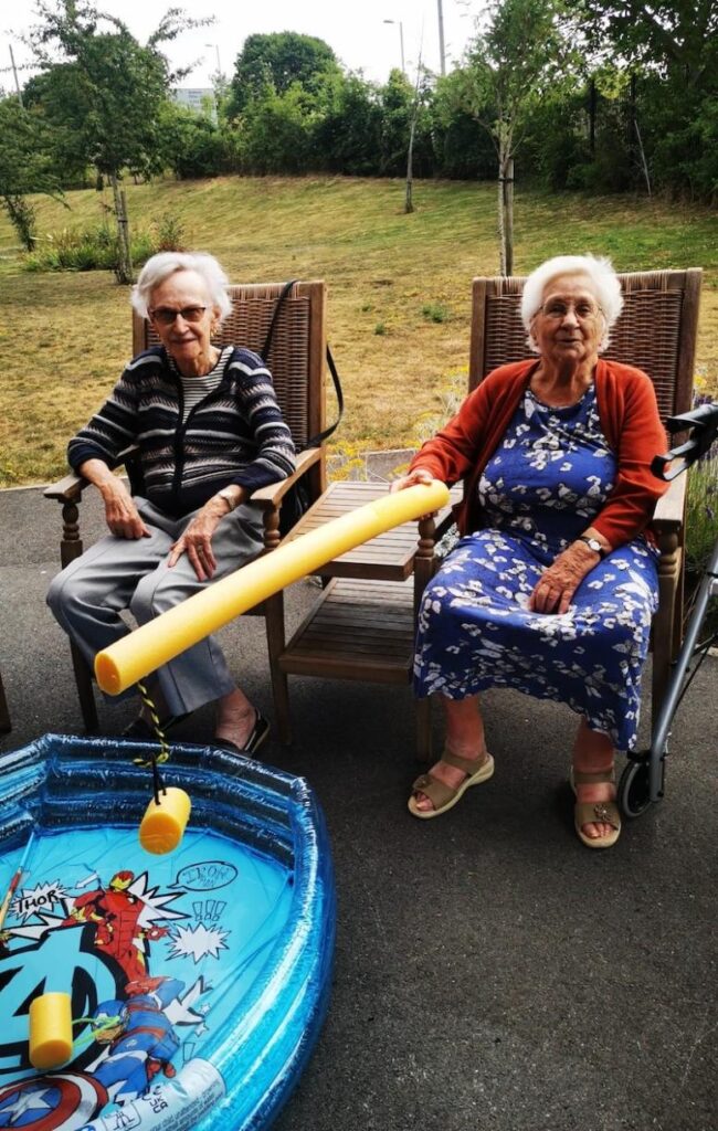 residents sat playing pool noodle fishing