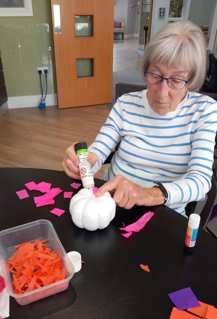 one of our residents decorating a pumpkin