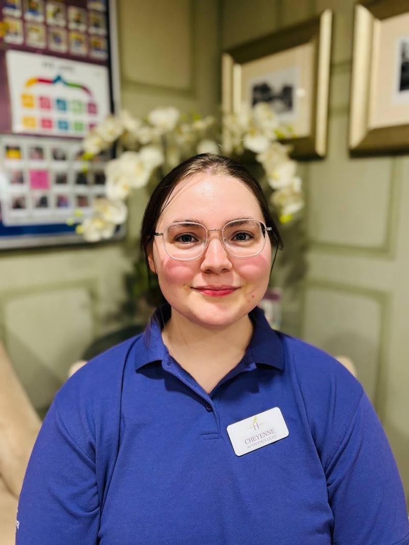 Our activities lead sat in an armchair wearing a purple shirt and smiling