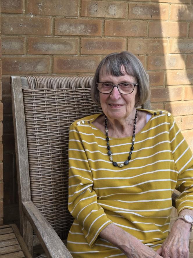 an older lady in a yellow top sat in a chair