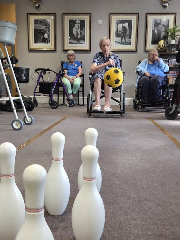 resident in wheelchair bowling a ball
